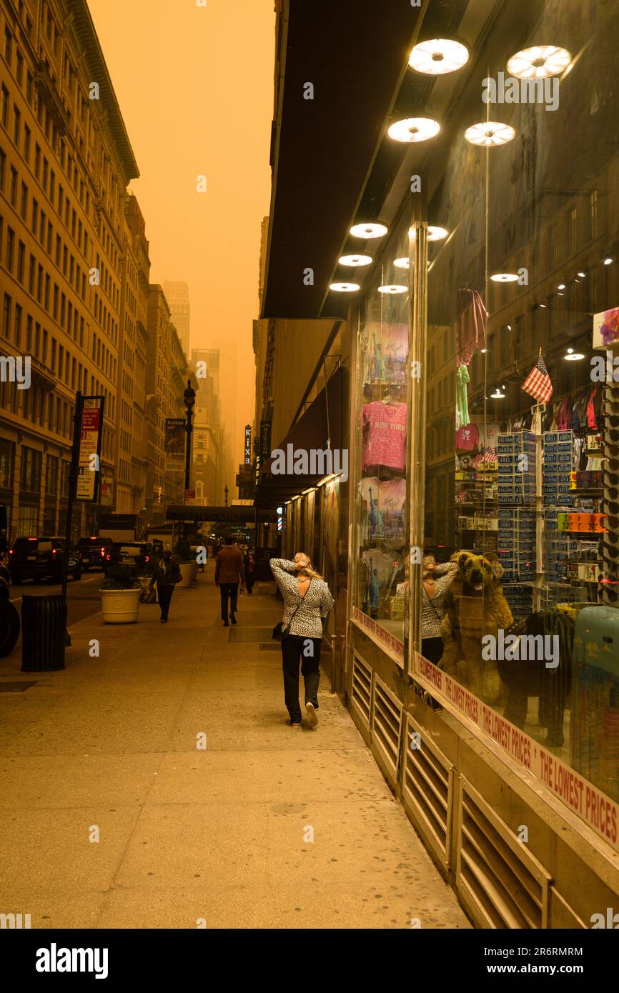 Fußgänger während der gefährlichen Luftqualität in New York City, verursacht durch kanadische Waldbrände. Bild aufgenommen an der 36. und 5. Avenue, 7. Juni 2023. Stockfoto