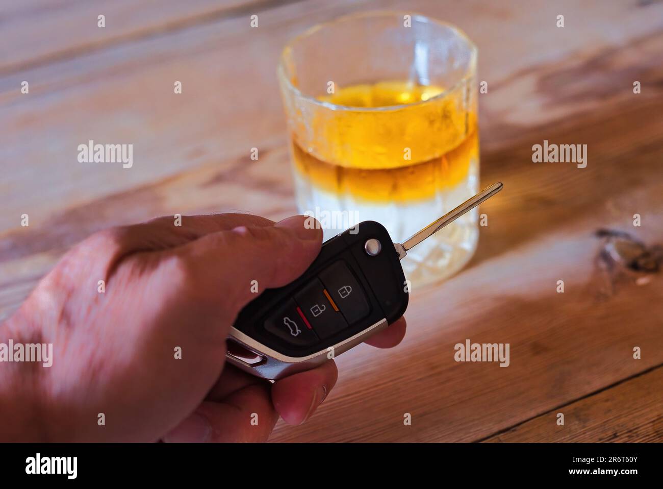 Glas mit Whiskey und Eis und Autoschlüssel auf Holzhintergrund. Trunkenheit am Steuer, Trunkenheitsrisiko am Steuer Stockfoto