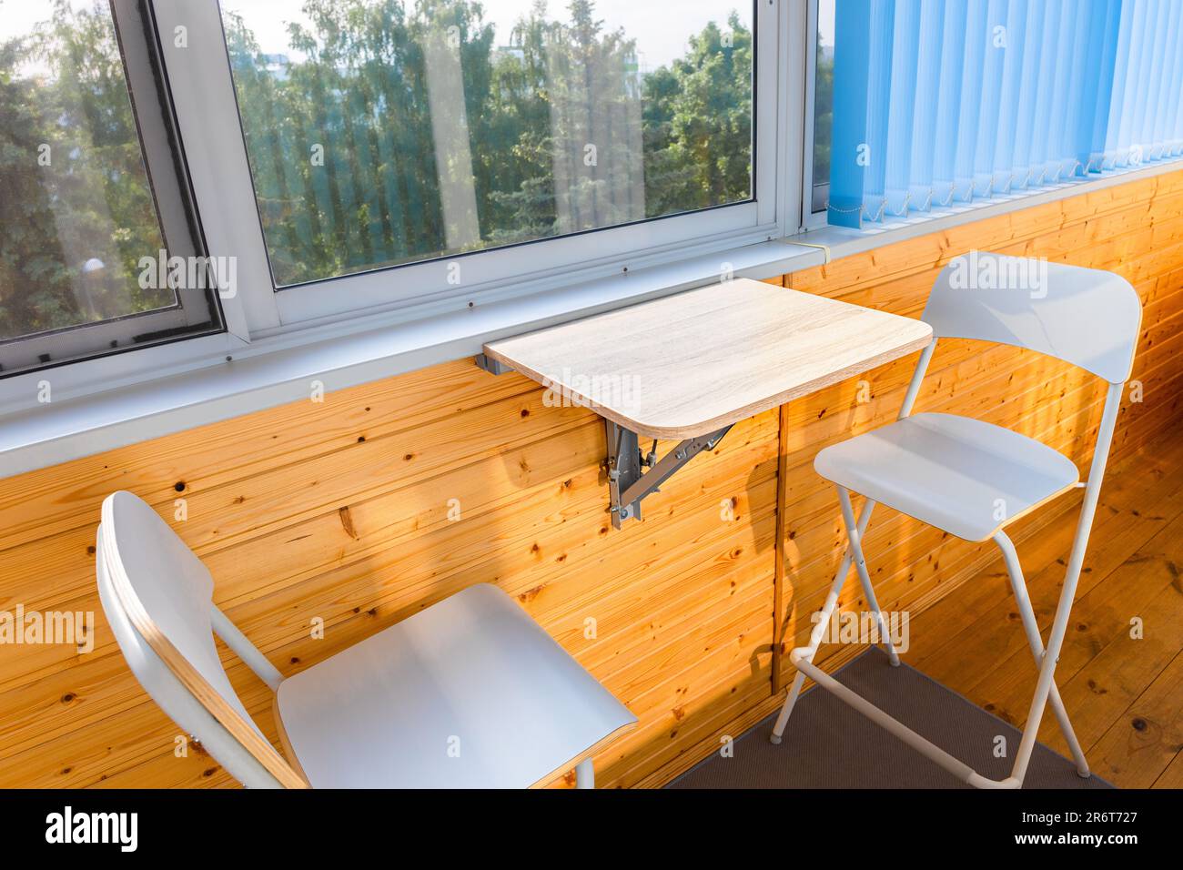 Klappbarer Holztisch, an der Wand befestigt. Klapptisch auf dem Balkon.  Tisch und Stühle auf dem Balkon. Hochwertiges Foto Stockfotografie - Alamy