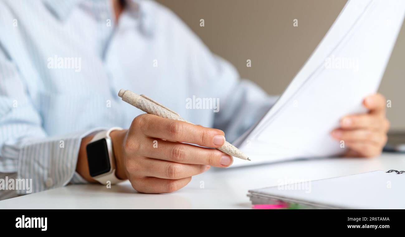 Stift in der Hand Nahaufnahme, Geschäftsmann sitzt am Schreibtisch und hält Stift und Papierdokumente in den Händen. Stockfoto