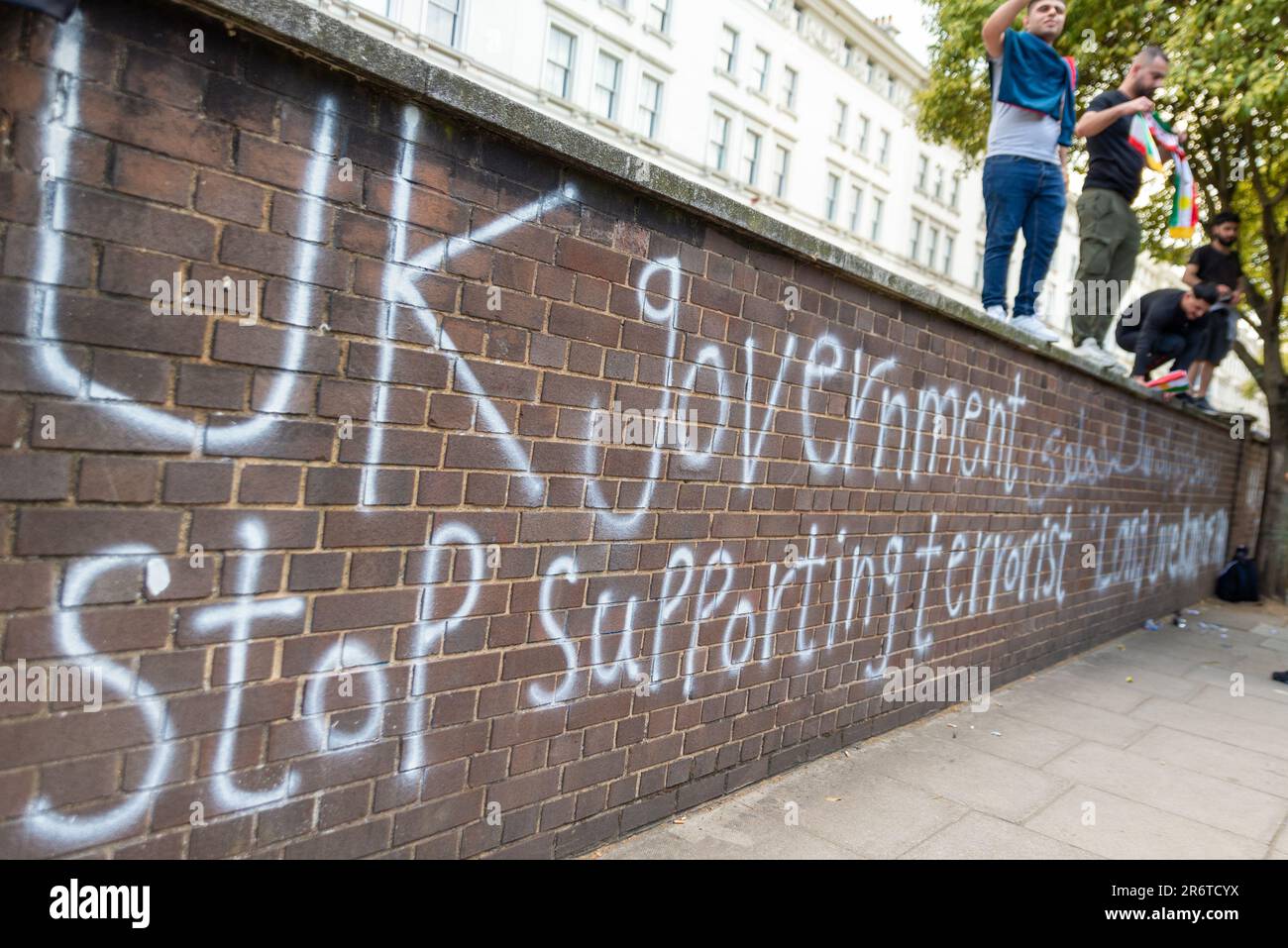 Knightsbridge, London, Großbritannien. 11. Juni 2023. Demonstranten versammelten sich vor der Botschaft der Islamischen Republik Iran in London und protestierten zugunsten des kurdischen Volkes, was eine umfassende Reaktion der Polizei veranlasste. Graffiti an der Wand, dass die britische Regierung den Terrorismus nicht mehr unterstützt Stockfoto