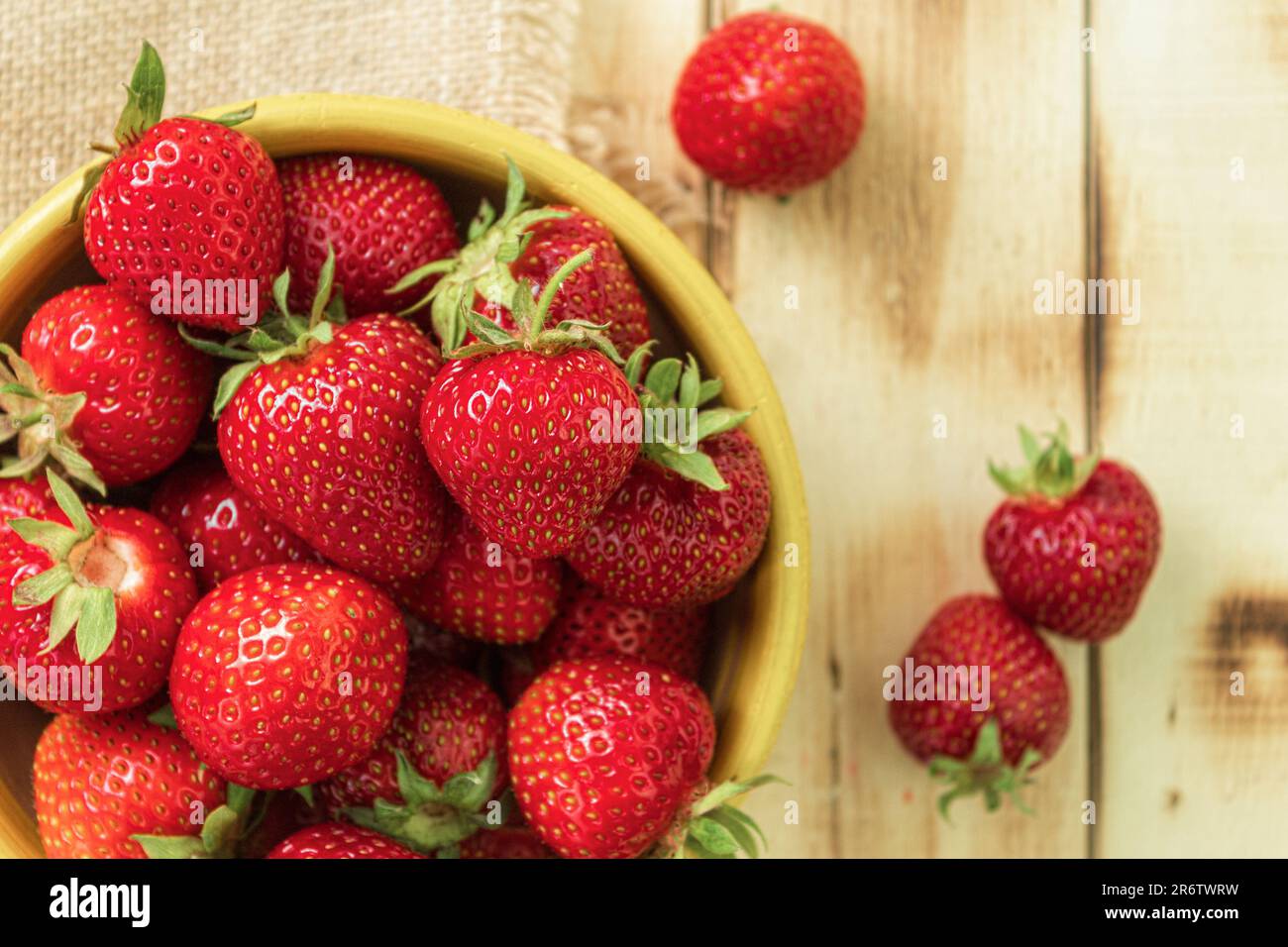 Frische Erdbeeren auf dunklem Holzhintergrund. Eine Gruppe roter reifer Erdbeeren aus der Nähe. Speicherplatz kopieren. Draufsicht. Schwarzer Hintergrund Stockfoto