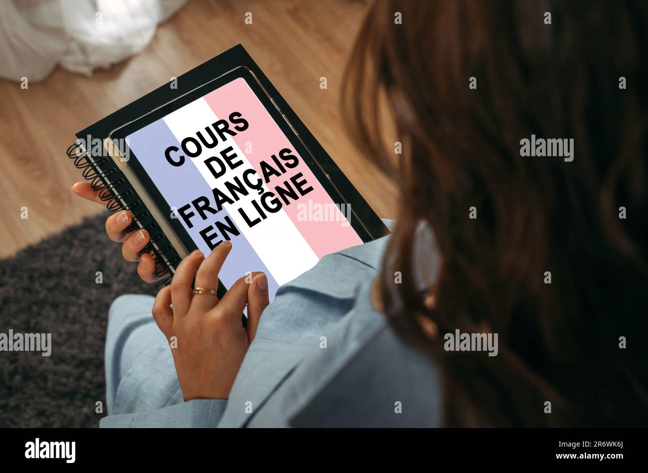 Online-Lernkonzept. Eine Frau hält ein Tablet in der Hand auf dem Bildschirm, auf dem es geschrieben ist – Online-Französisch lernen. Französische Inschrift. Stockfoto