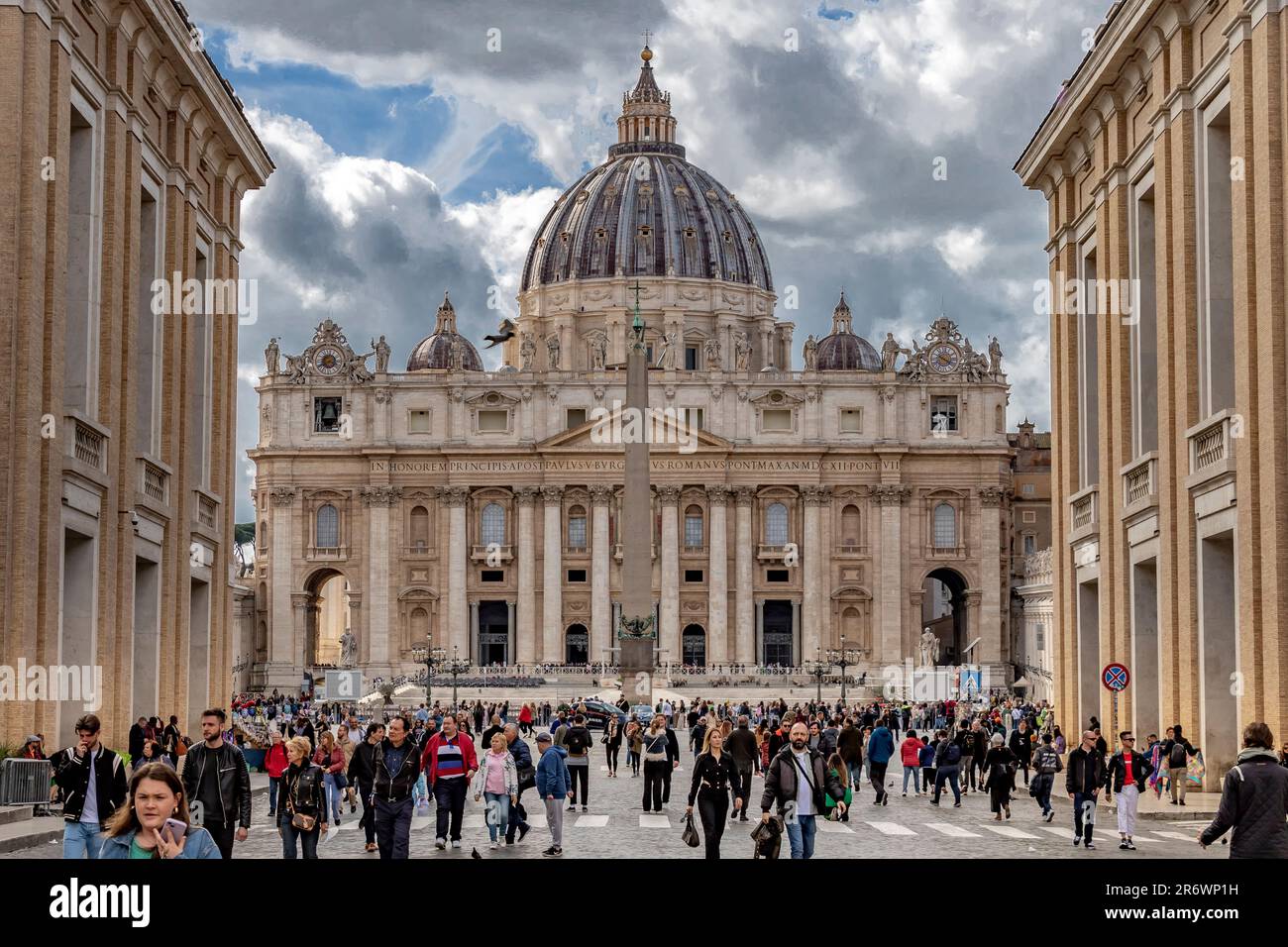 Menschen gehen entlang der Via della Conciliazione, der Straße der Vermittlung, der breiten Durchgangsstraße, die zum Petersdom, Rom, Italien führt Stockfoto