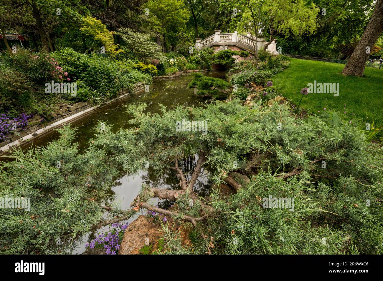 Intimes, hochauflösendes urbanes Landschaftsbild einer romantischen Brücke über den Fluss im Parque Monceau, Paris, Frankreich Stockfoto