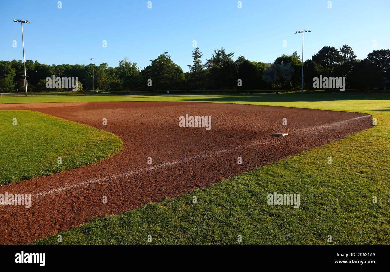 Die erste Base auf dem Baseballfeld wurde am frühen Morgen gedreht. Stockfoto