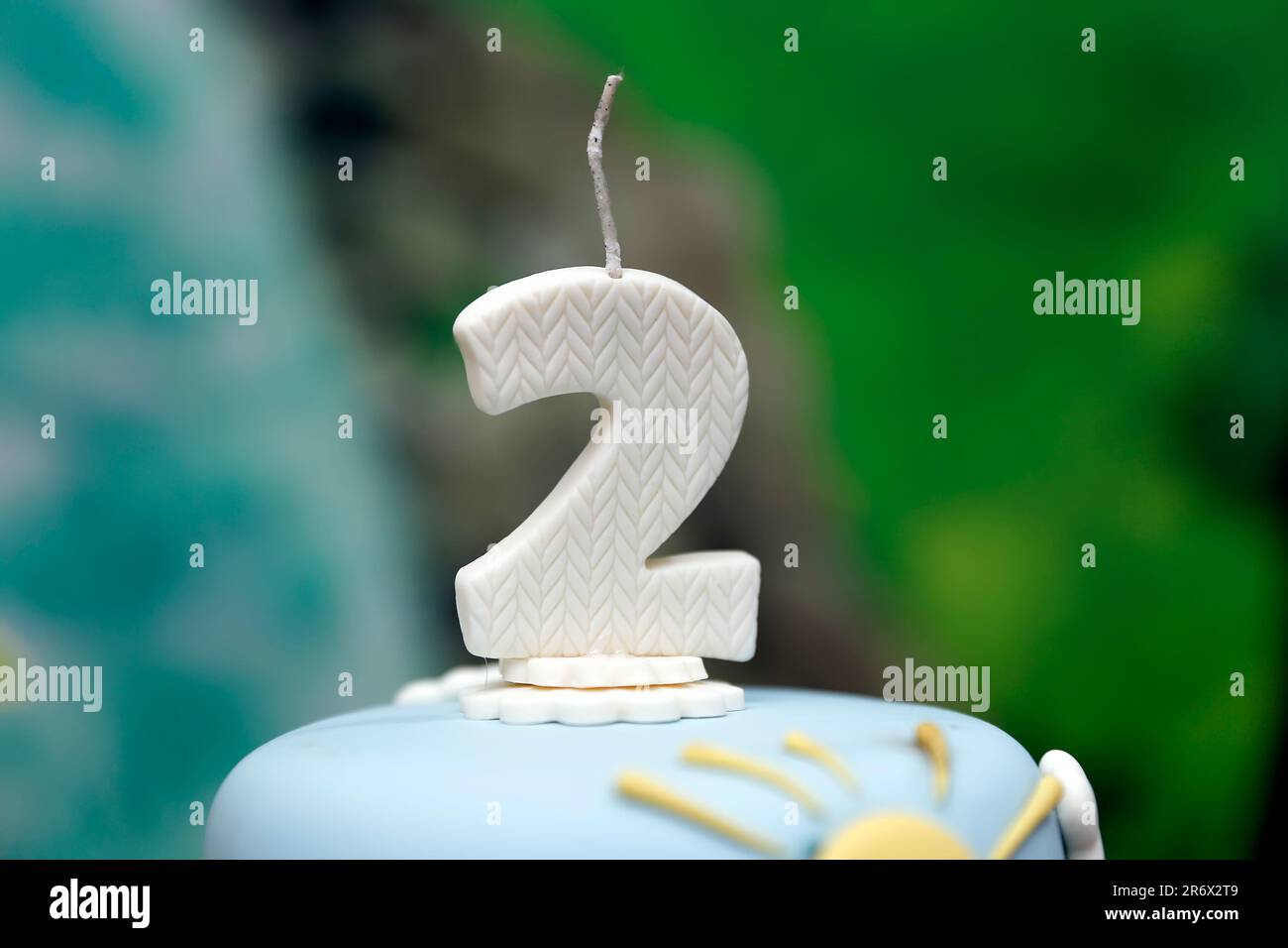 Detail der Nummer zwei oben auf dem Geburtstagskuchen, 2. Geburtstag, weißer Kuchen, 2 Jahre alte Geburtstagskuchen-Kerze Stockfoto