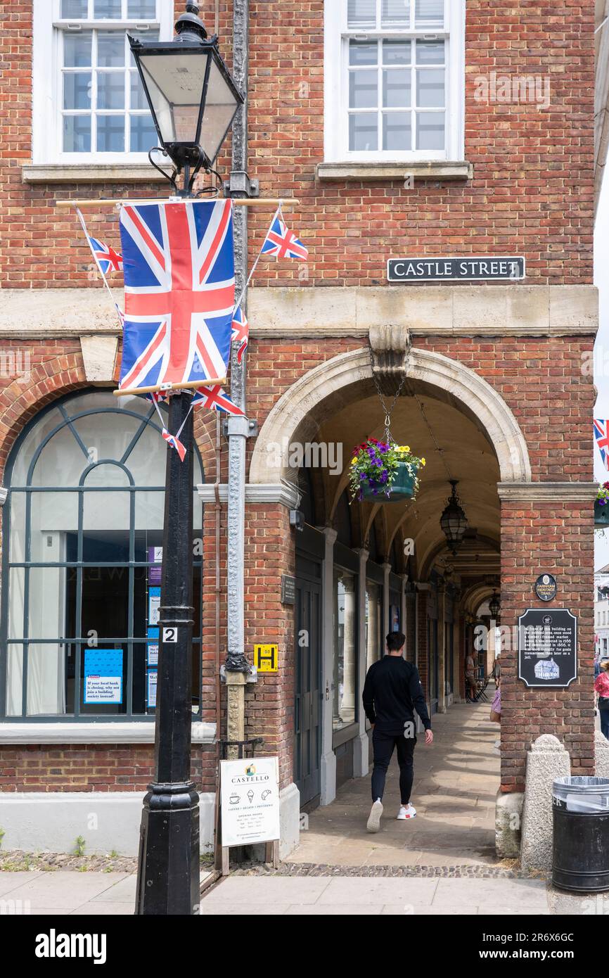 Eine britische Flagge und das Rathaushaus in Farnham - ein denkmalgeschütztes Ziegelgebäude im Stil des 18. Jahrhunderts mit einer offenen Arkade im Erdgeschoss. UK Stockfoto