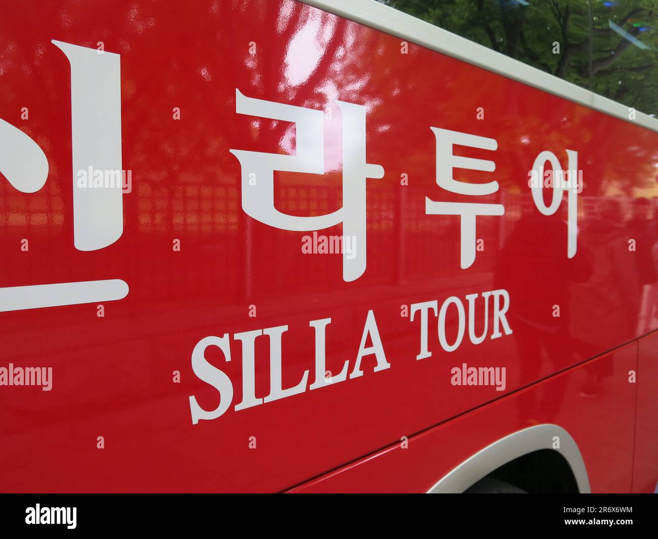 Ein hellroter Bus mit der Aufschrift „Silla Tour“; einer der Touristenbusse in der UNECSO-Weltkulturerbestätte Gyeongju, Südkorea. Stockfoto