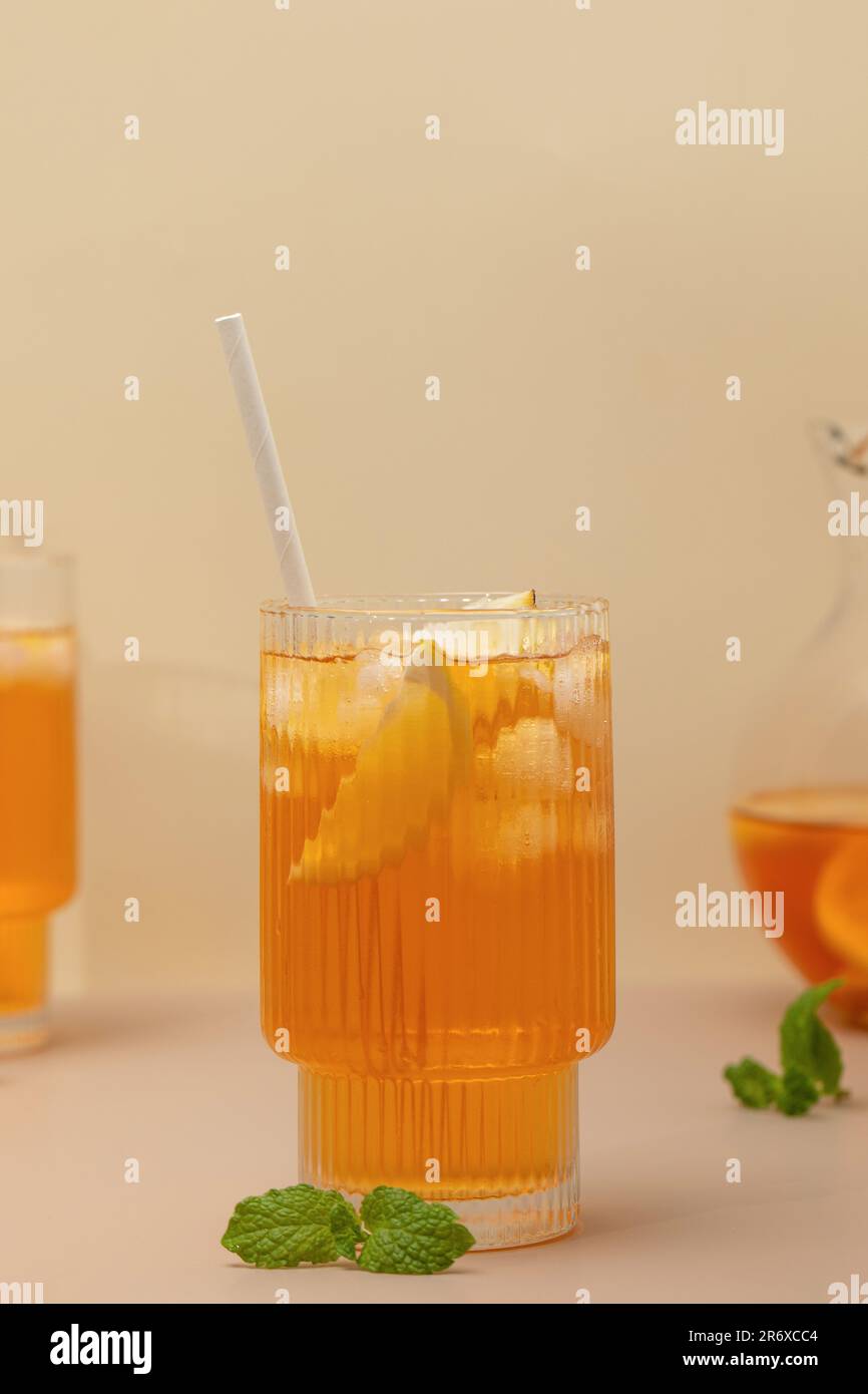 Ein Glas kalten Tee, Eiswürfel, Zitronenscheiben und einen Pfefferminzzweig. Kühle Sommergetränke. Stockfoto