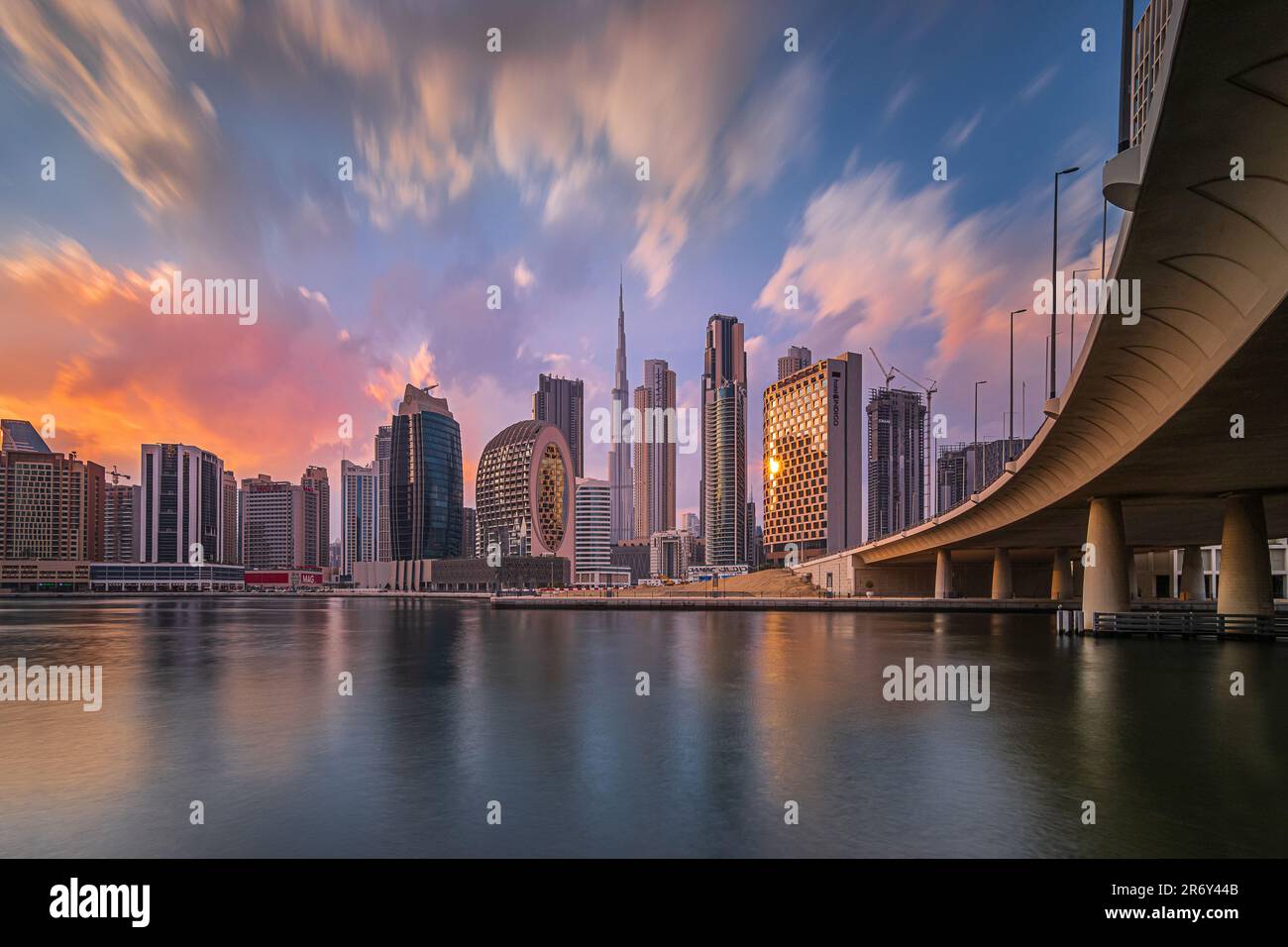 Farbenfroher Sonnenuntergang in dubai. Geschäftszentrum der Stadt mit Bürogebäuden und Wolkenkratzern rund um den Burj Khalifa. Die Skyline des Finanzviertels am Abend Stockfoto