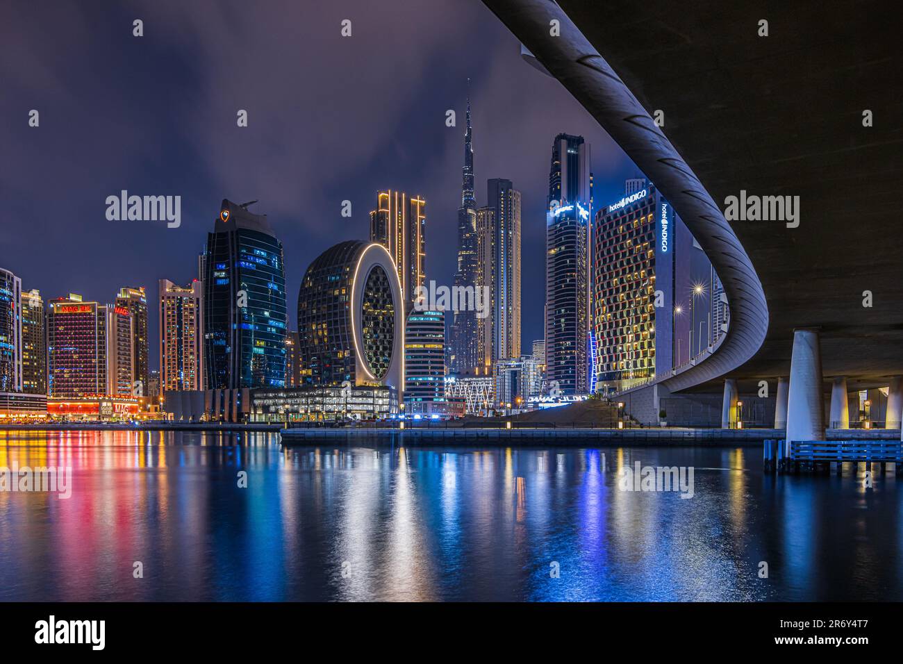 Blick auf die Skyline von Dubai bei Nacht. Finanzzentrum der Stadt in den Vereinigten Arabischen Emiraten. Wolkenkratzer beleuchtet zur Blue Hour mit gebogenem Kurs Stockfoto