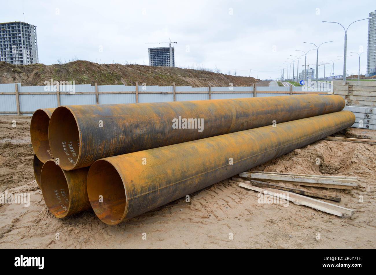 Große Abwasserrohre aus Eisenmetall mit großem Durchmesser für den industriellen Bau von Wasser- oder Abwasserleitungen auf einer Baustelle während der Wiedereinbauphase Stockfoto