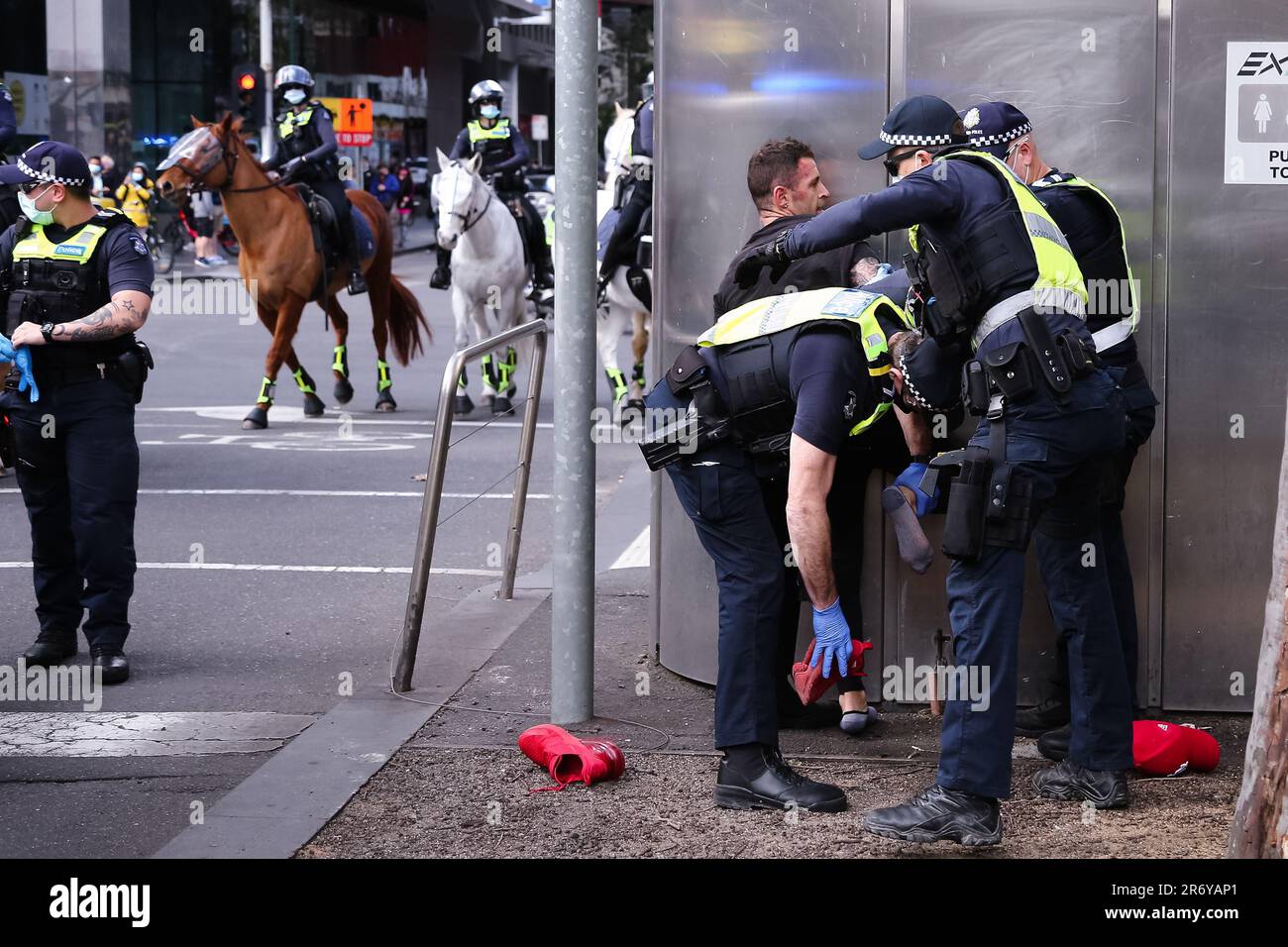 MELBOURNE, VIC - AUGUST 21: Die Polizei wird dabei gesehen, wie sie einen Demonstranten festnimmt und seine Schuhe während des Protests zur Freiheit am 21. August 2021 in Melbourne, Australien, auf Drogen überprüft. Als Reaktion auf die COVID-19-Beschränkungen der Regierungen und die fortgesetzte Aufhebung der Freiheiten werden im ganzen Land Freiheitsproteste durchgeführt. Stockfoto