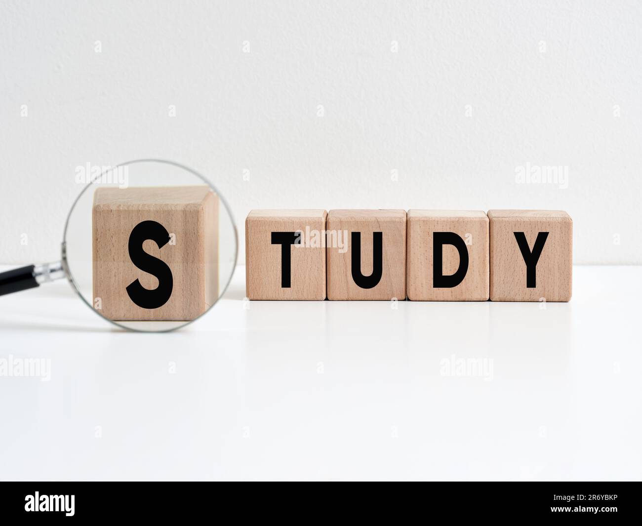 Das Wort Studie über Holzwürfel mit einer Lupe. Bildungskonzept. Stockfoto