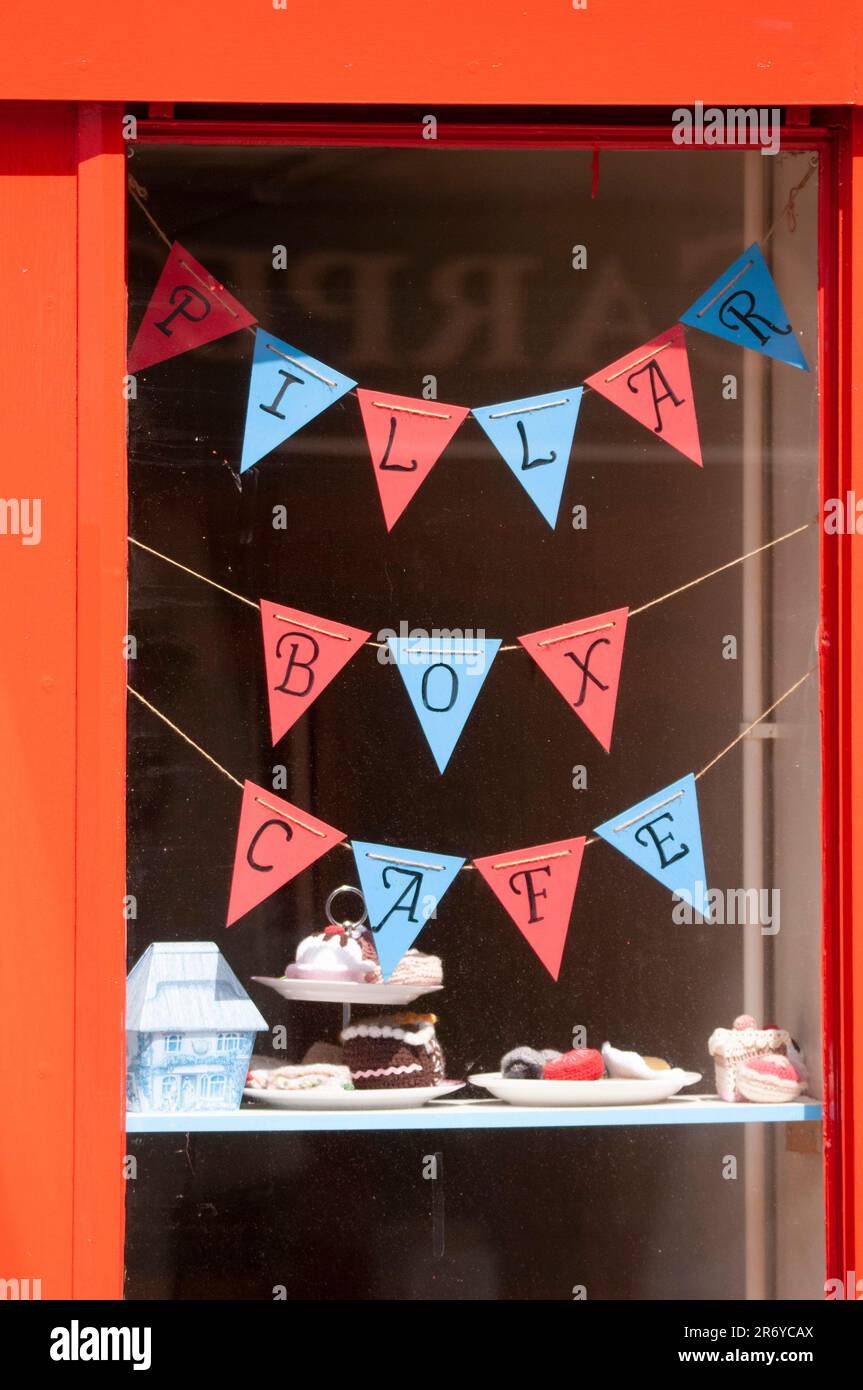 Bunting und Kuchen im Fenster des Pillar Box Cafés, Haltwhistle, Northumberland Stockfoto