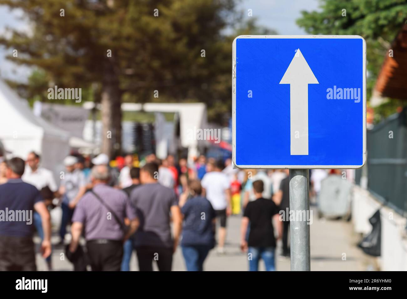 Eine Gruppe von Fußgängern, die die Einbahnstraße entlang laufen, mit großem Verkehrsschild, selektiver Fokus Stockfoto