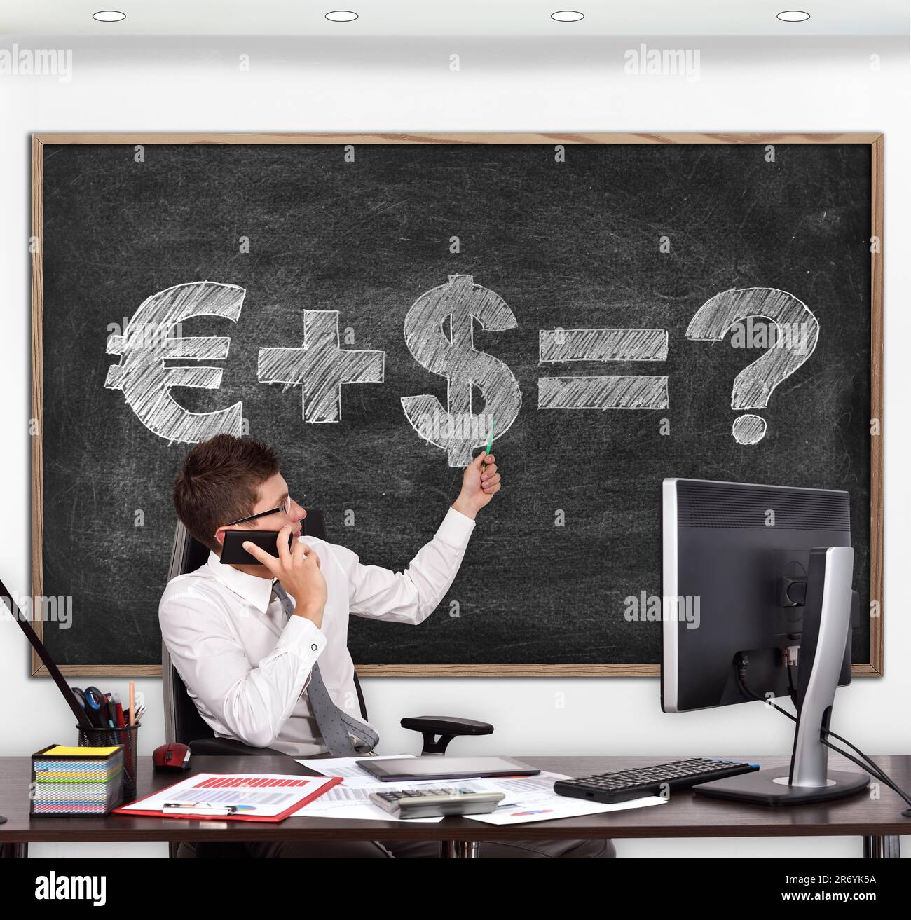 Ein Geschäftsmann im Zimmer zeigte auf die Tafel mit der Formel des Geldes Stockfoto