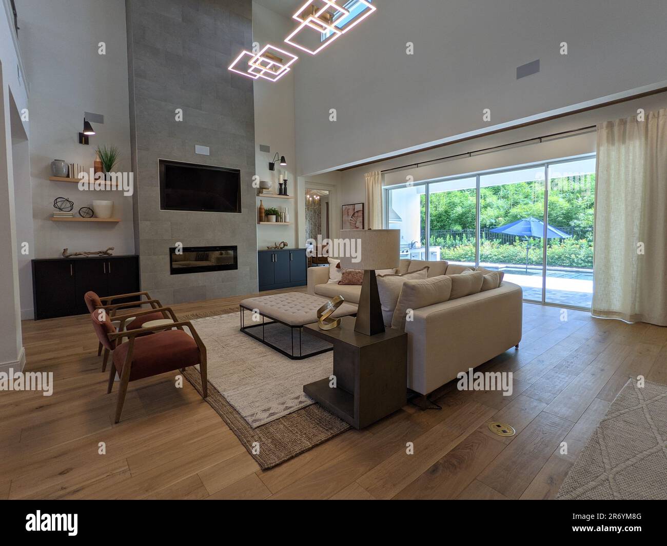Ein geräumiges Wohnzimmer, komplett mit einer Reihe von Möbelstücken und Beleuchtungskörpern. Stockfoto