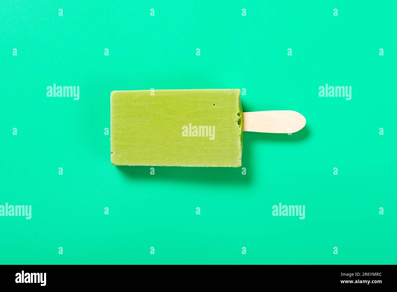 Eis am Stiel mit Matcha- und Milchgeschmack von oben auf grünem Hintergrund Stockfoto