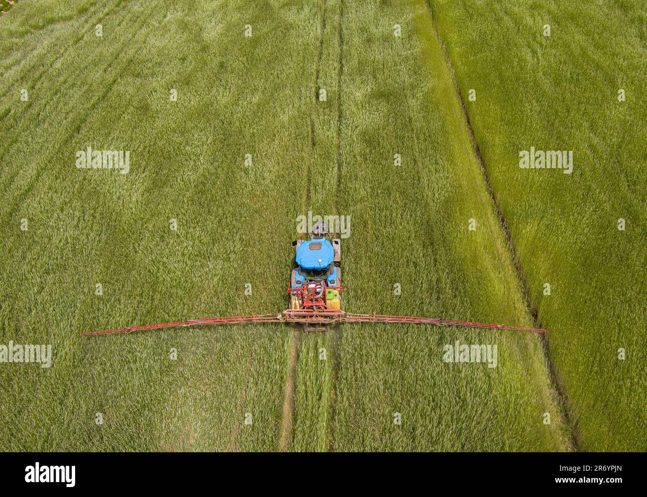 Luftaufnahme des Traktors auf dem landwirtschaftlichen Feld beim Spritzen Stockfoto