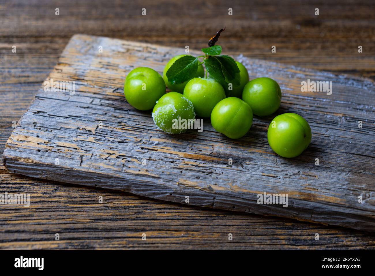 Frische, reife organische grüne Pflaume, Holzhintergrund, Nahaufnahme. Stockfoto