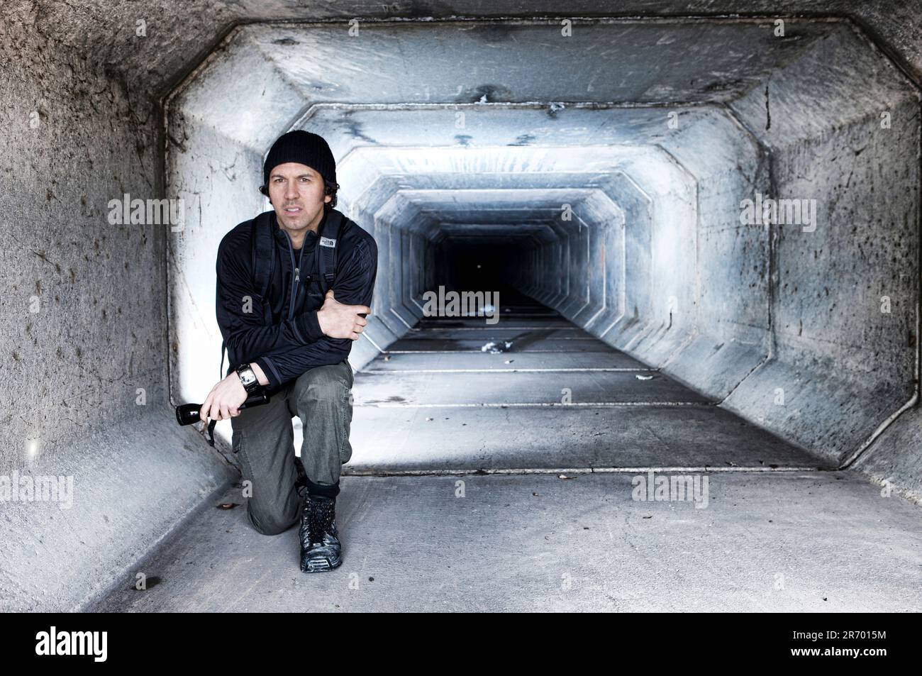 Autor Matthew O'Brien kniet in einem Tunnel unter dem Las Vegas Strip. Stockfoto
