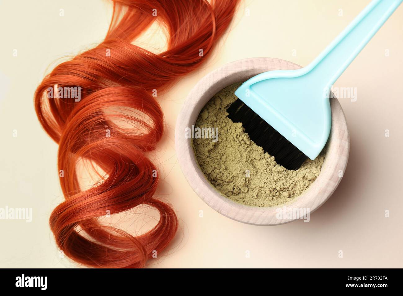 Schüssel mit Hennapulver, Bürste und rotem Strang auf beigefarbenem  Hintergrund, flach liegend. Natürliche Haarfarbe Stockfotografie - Alamy