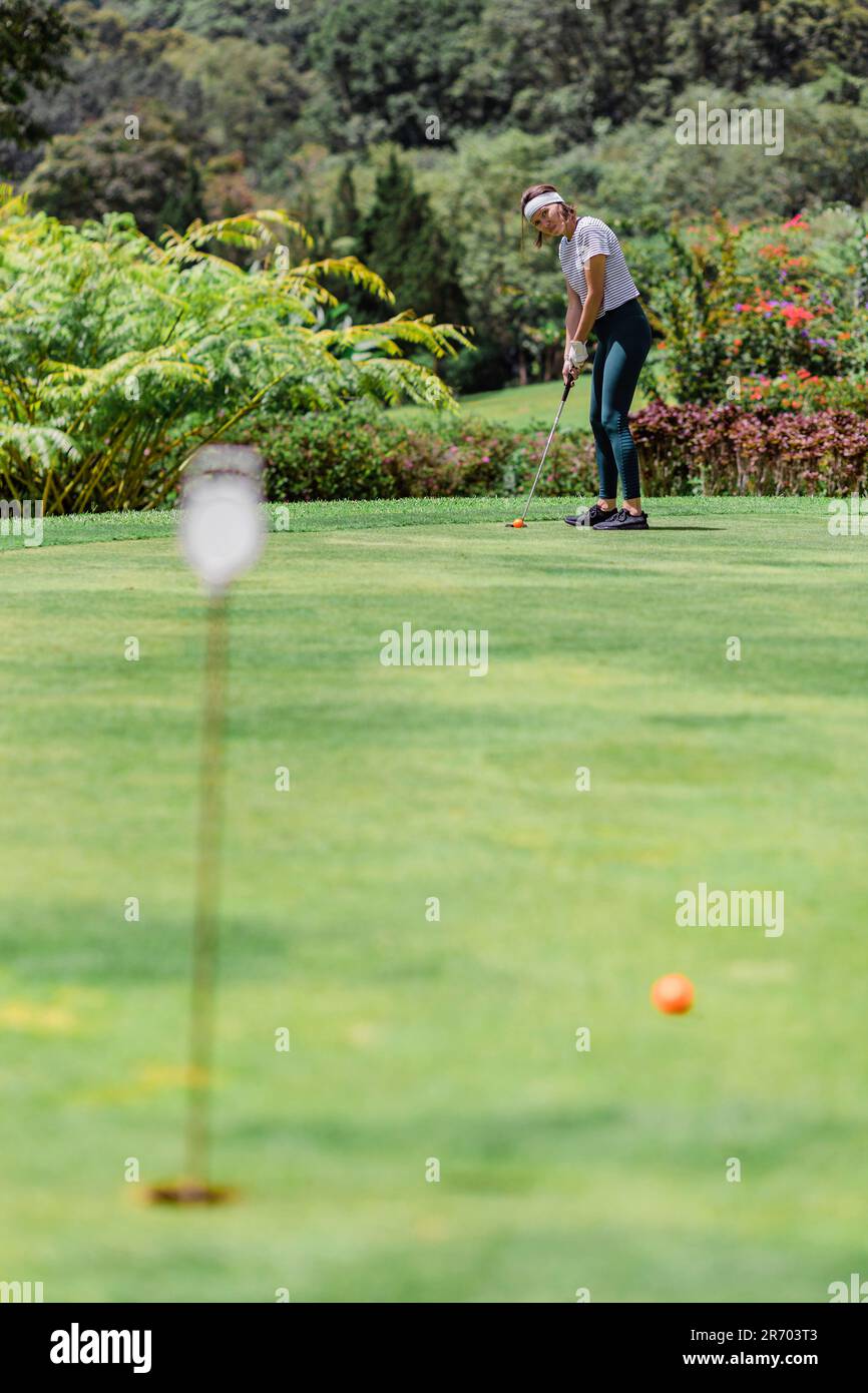Entfernte Aussicht auf eine Frau, die Golf spielt, Bedugul, Bali, Indonesien Stockfoto