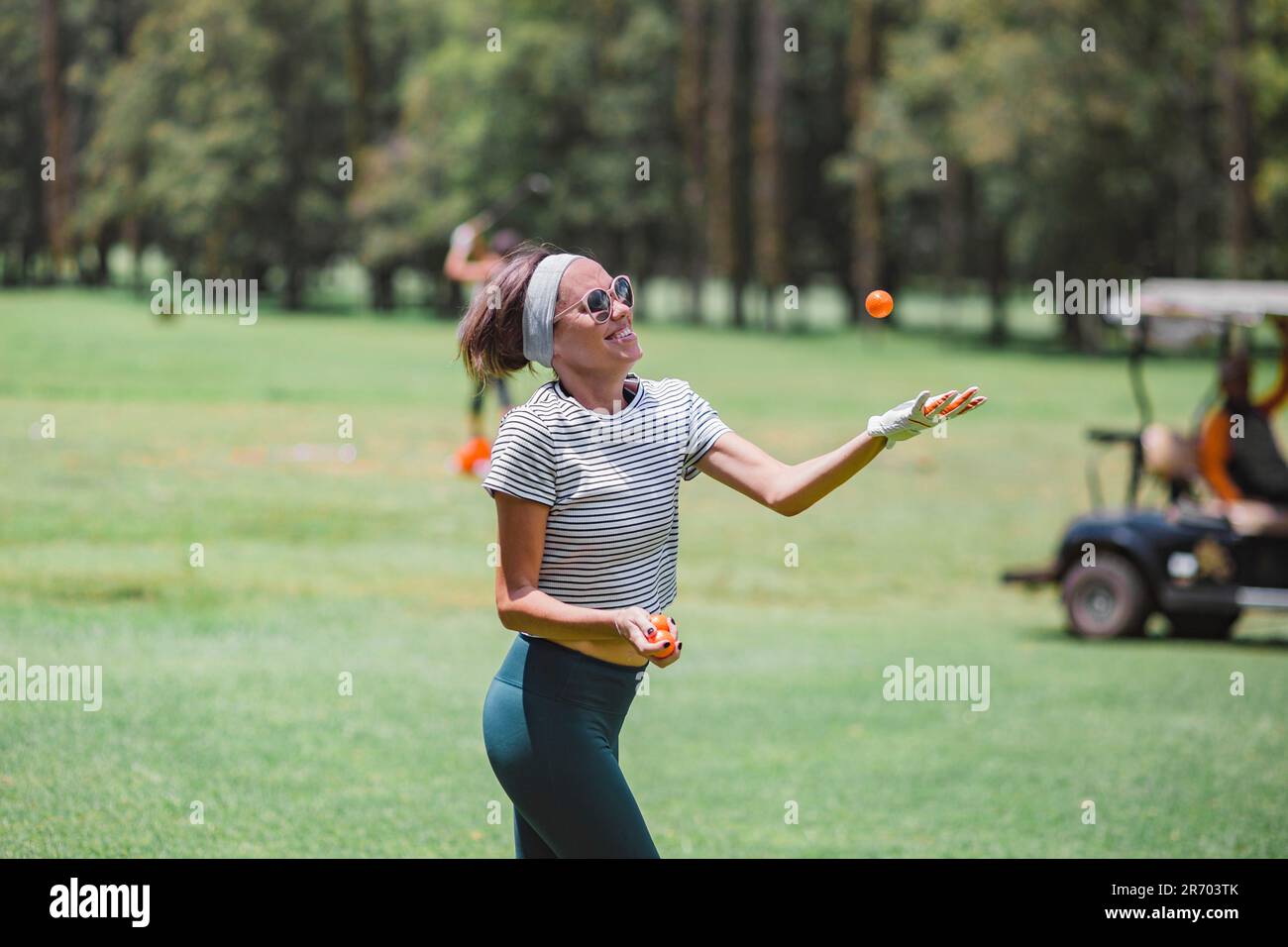 Frau jongliert mit Golfbällen auf dem Golfplatz, Bedugul, Bali, Indonesien Stockfoto