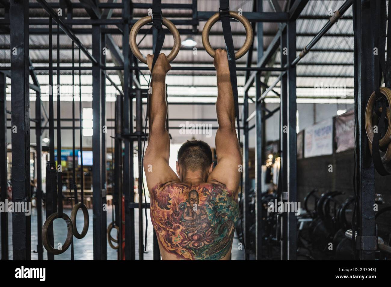 Ein Mann, der mit Turnringen trainiert, im Fitnessstudio, Canggu, Bali, Indonesien Stockfoto
