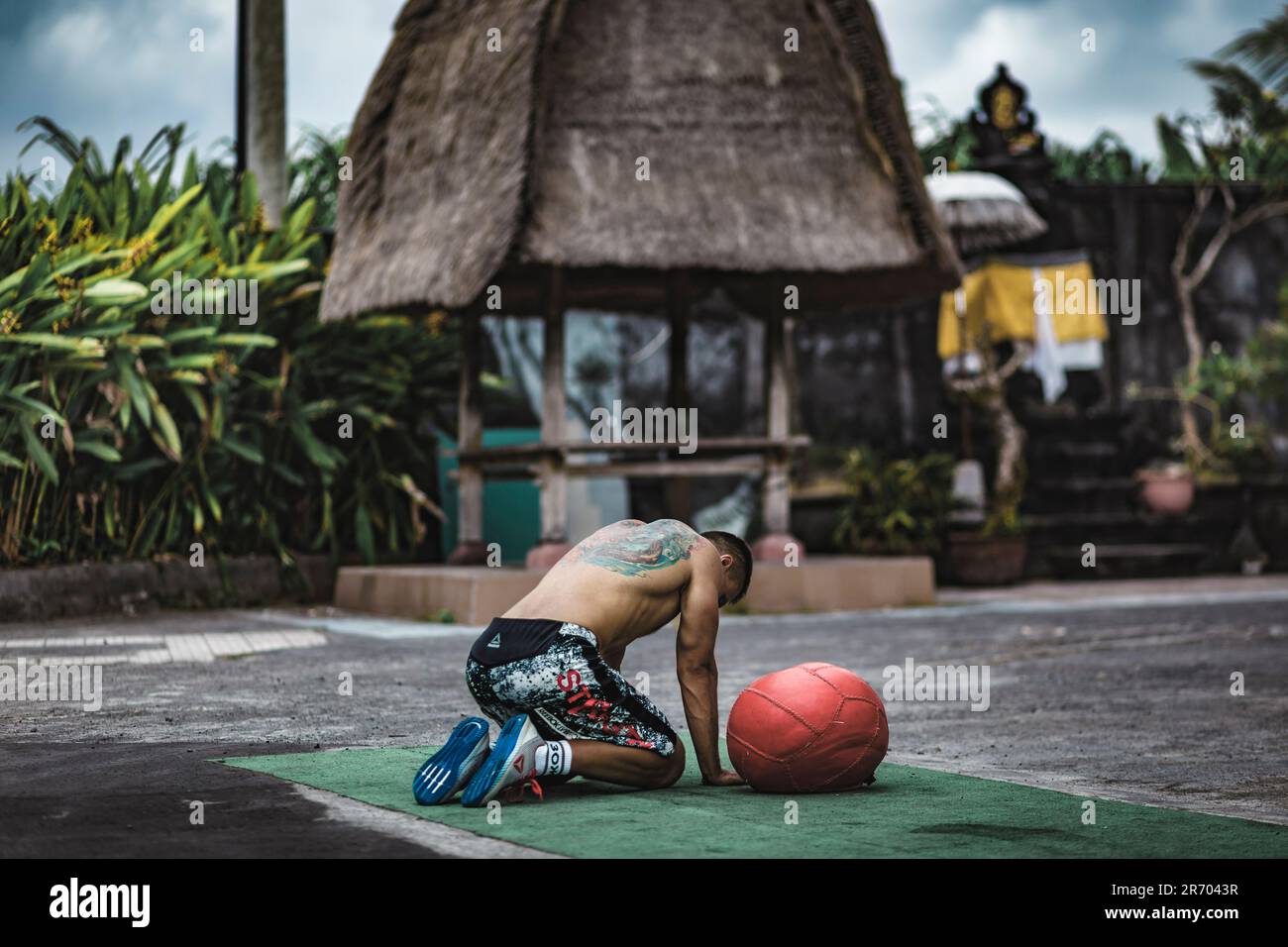 Müder Mann nach Bewegung mit Medizinball, Canggu, Bali, Indonesien Stockfoto