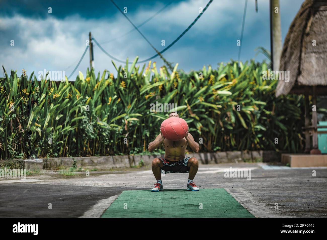 Mann, der mit Medizinball trainiert, Â Canggu, Bali, Indonesien Stockfoto