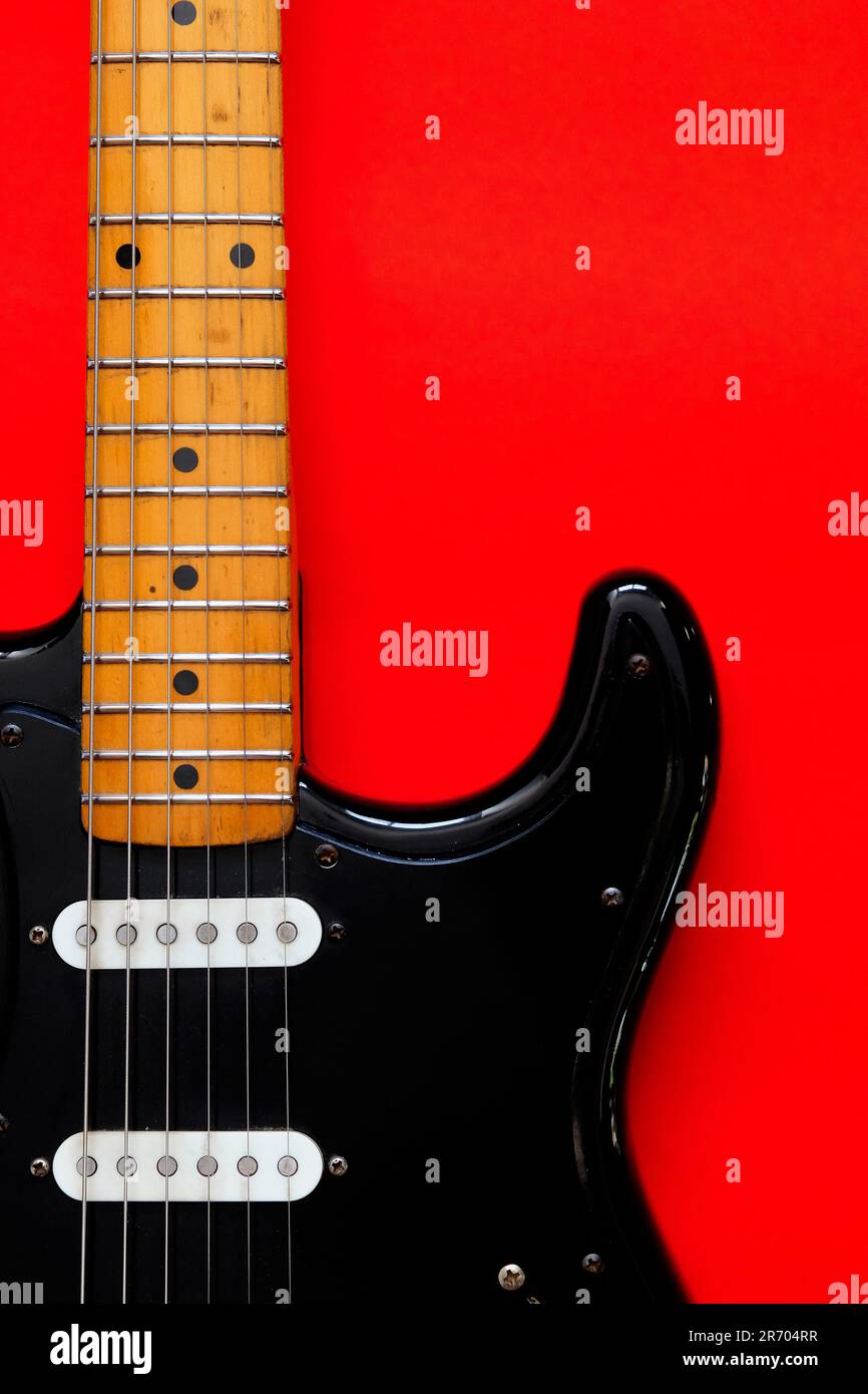 Elektrische Gitarre auf rotem Hintergrund. Stockfoto