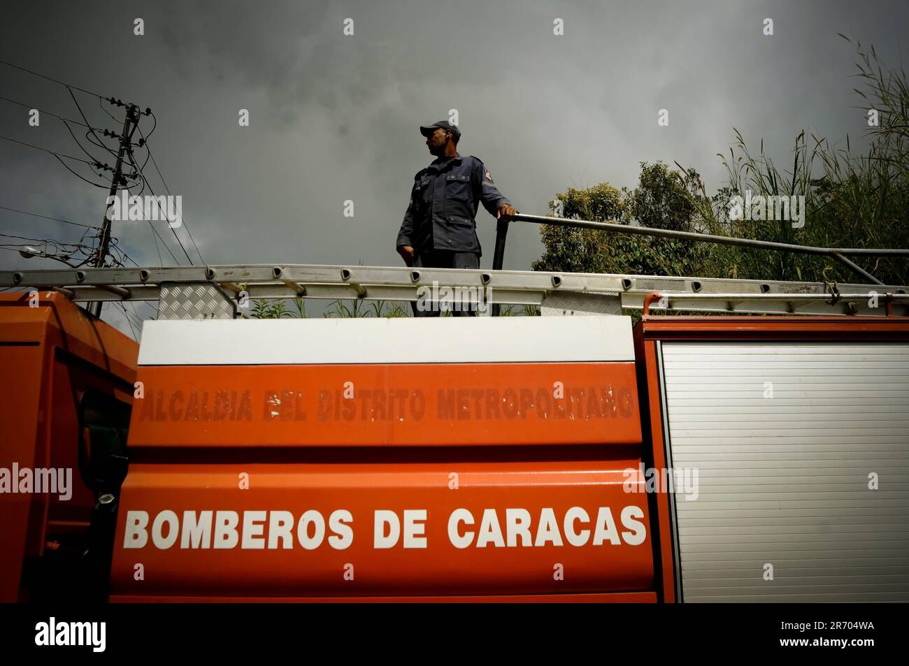 Ein Feuerwehrmann füllt den Tank seines Trucks in einem Slum in Caracas, Venezuela. Stockfoto