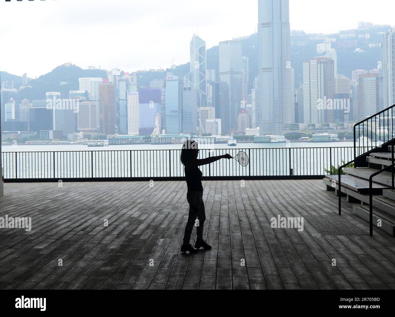 Eine Frau, die vor dem M+ Museum im West Kowloon Cultural District in Hongkong trainiert. Stockfoto