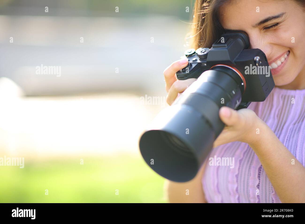 Glücklicher Fotograf, der ein Foto in einem Park mit Kopie macht Stockfoto