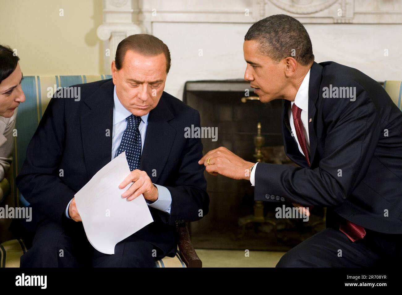 Washington, DC - 15. Juni 2009 -- US-Präsident Barack Obama (R) spricht vor dem Übersetzer von Ministerpräsident Silvio Berlusconi von Italien, bevor er am Montag, 15. Juni 2009 im Oval Office des Weißen Hauses vor der Presse spricht. Die beiden Staats- und Regierungschefs trafen sich im Vorfeld des G8-Gipfels, der nächsten Monat in Italien stattfinden wird.Kredit: Matthew Cavanaugh - Pool über CNP Stockfoto