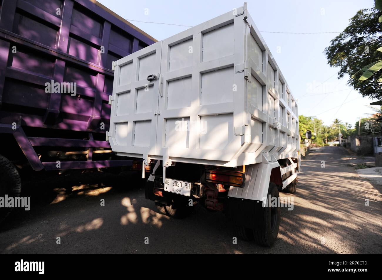 10. Juni 2023, Kulonprogo, Yogyakarta, Indonesien: Ein Mini-Lkw fährt am 12. Juni 2023 vor einem echten Lkw im Dorf eines Einwohners in Kulonprogo, Yogyakarta. Der Lkw verwendet einen modifizierten Motorradmotor. Der Spielzeugwagen ist so konstruiert, dass er im Allgemeinen einem Lkw ähnelt, hat jedoch wesentlich kleinere Abmessungen mit Vorwärts-, Rückwärts- und Hubfunktionen hinter dem Bett. Ein junger Mann namens Imam, Eigentümer von Rimbono Garage, sagte, dass der Zweck der Herstellung des Mini-Lkws anfangs nur darin bestand, Fananfragen in sozialen Medien zu erfüllen. Denn vor der Herstellung von Spielzeugautos war die Karosserie des Lkws rein handgefertigt Stockfoto