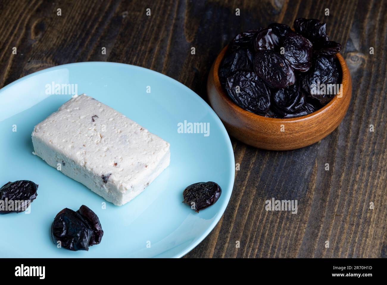 Süßer Hüttenkäse mit Pflaumenscheiben, Milchprodukten und getrockneten Pflaumenfrüchten Stockfoto