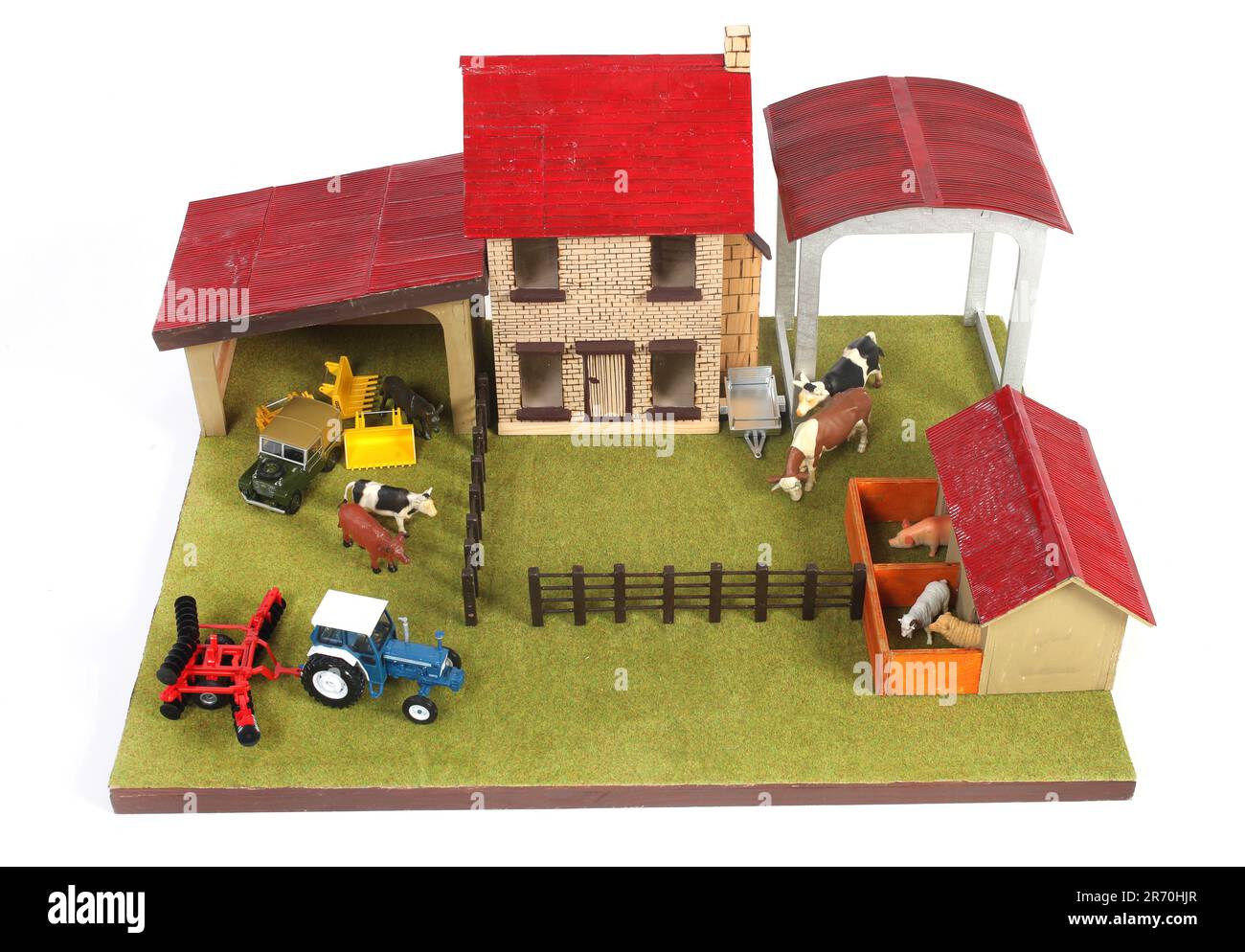 Ein hölzernes Bauernhofspielzeug mit Tieren und einem Traktor Stockfoto