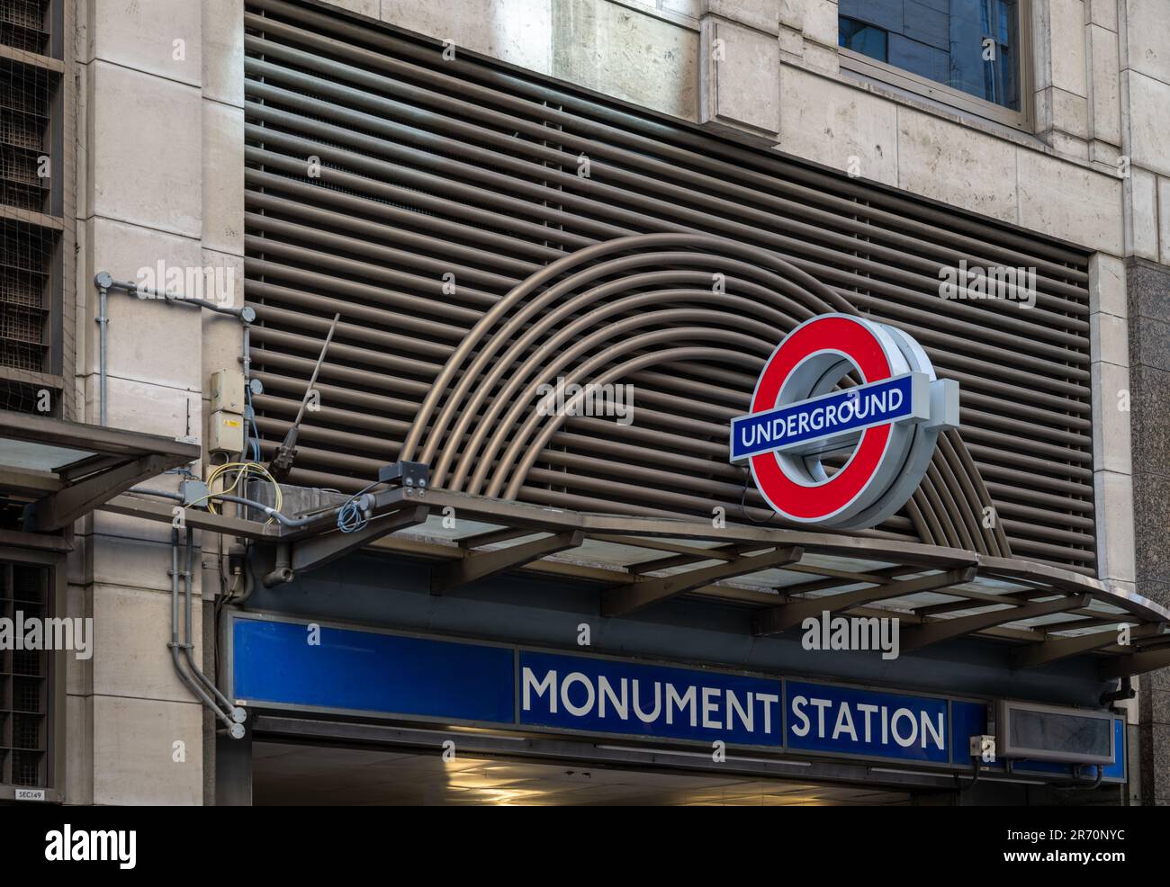 London, Großbritannien: Eingang zur U-Bahn-Station Monument. Eine Station im Londoner U-Bahn-Netz. Name des Bahnhofs und das Logo der Londoner U-Bahn. Stockfoto