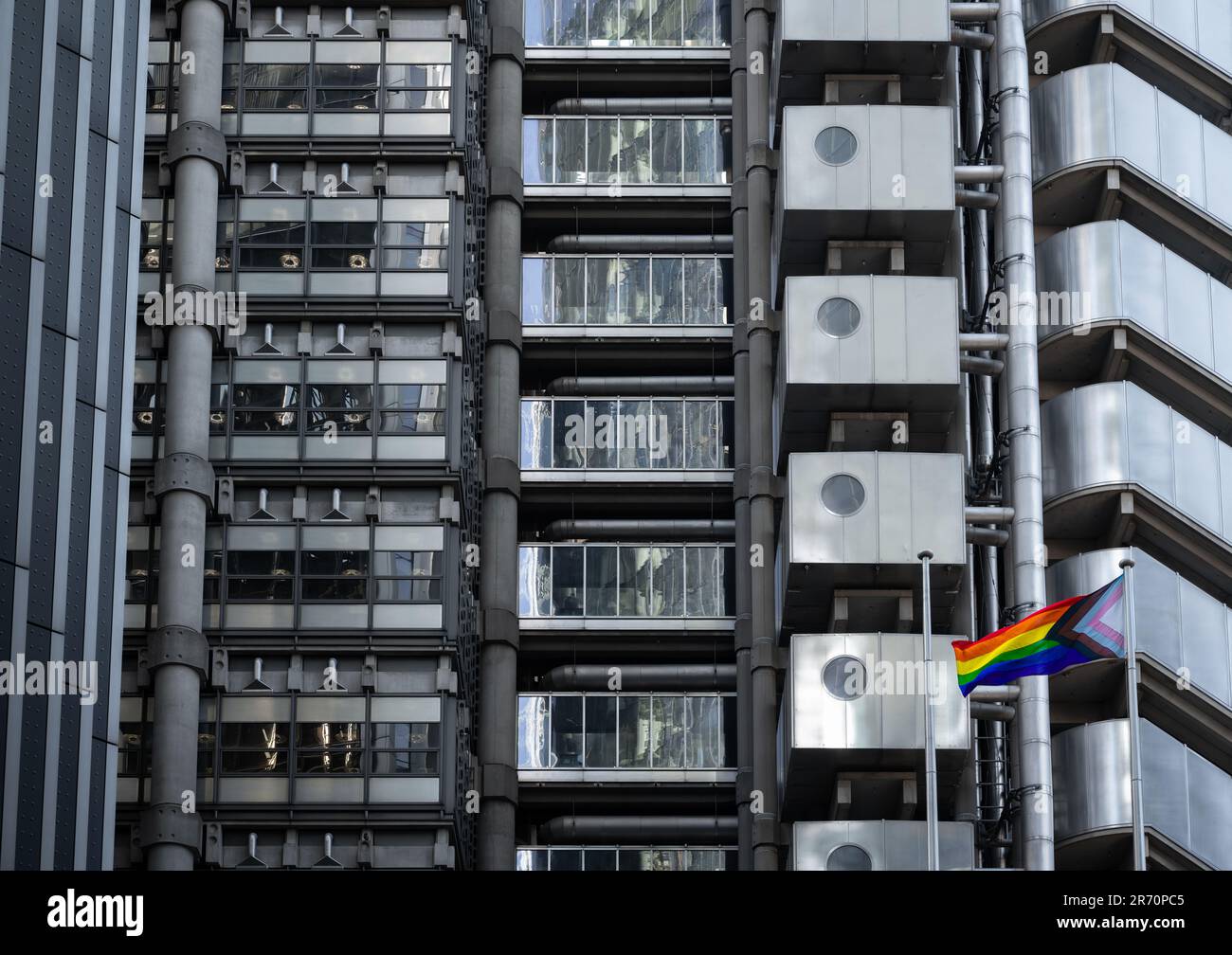 Die „Progress“ Pride Flag, eine aktualisierte Version der Rainbow Pride Flag, fliegt vor dem Lloyds of London-Gebäude in der City of London, Großbritannien. Stockfoto
