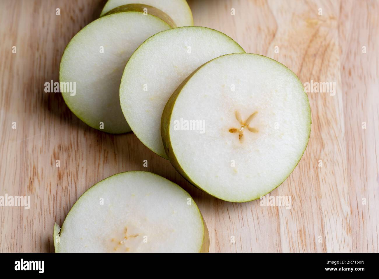 Zerstückelte Birne auf dem Tisch, reife Birne in Scheiben geschnitten Stockfoto