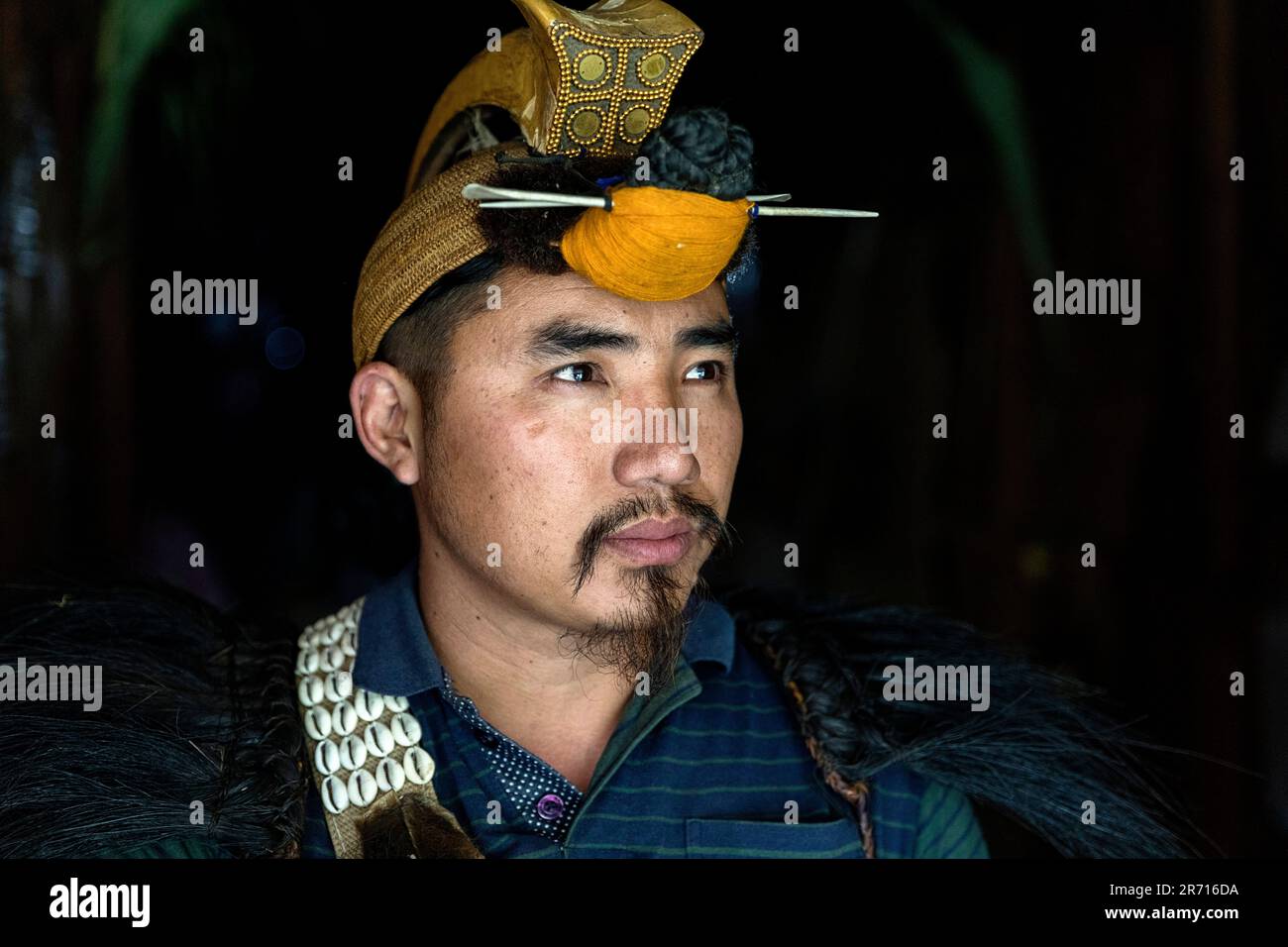 Porträt eines Nyishi-Mannes in traditioneller Stammeskleidung mit zeremoniellem Hornvogel-Federmütze auf dem Kopf, Arunachal Pradesh, Indien Stockfoto