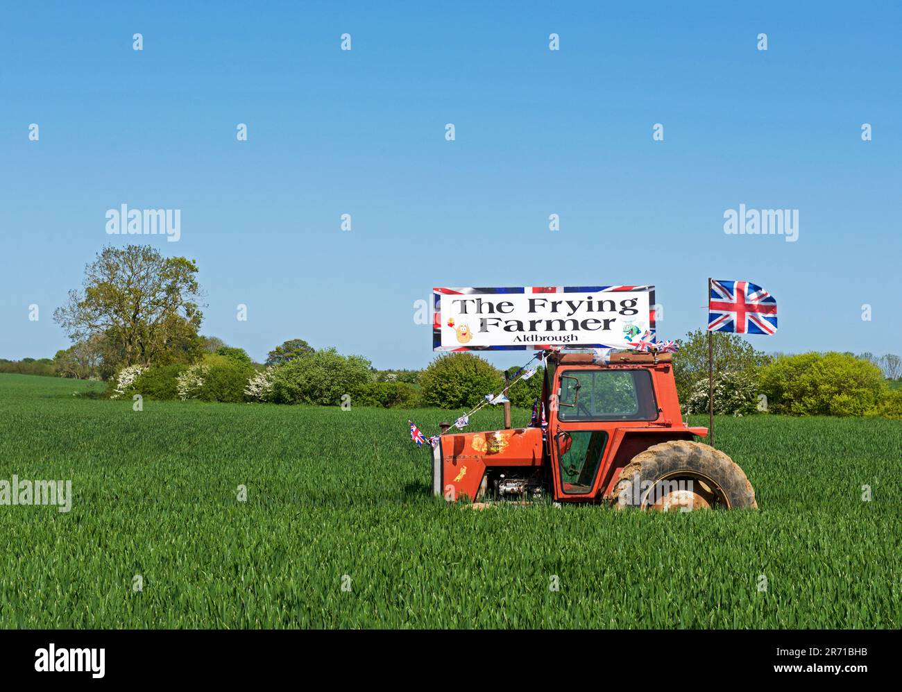 Werbebanner auf altem Traktor, das für den Frying Farmer Fish & Chip Shop in Aldbrough, Holderness, East Yorkshire, England, wirbt Stockfoto