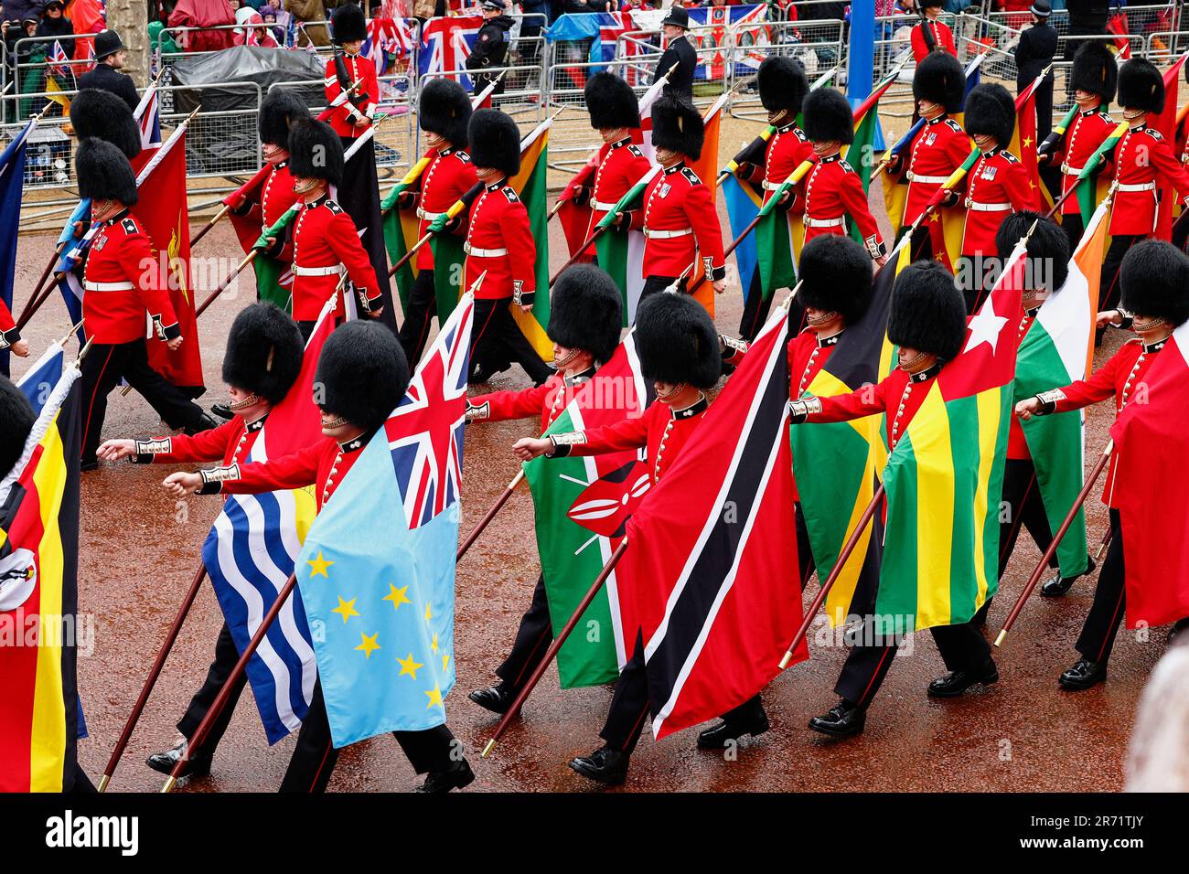 England, London, The Mall, Grenadier Guards marschieren mit Flaggen aus den Commonwealth-Ländern während der Krönung von König Karl III. Auf einem regnerischen M Stockfoto