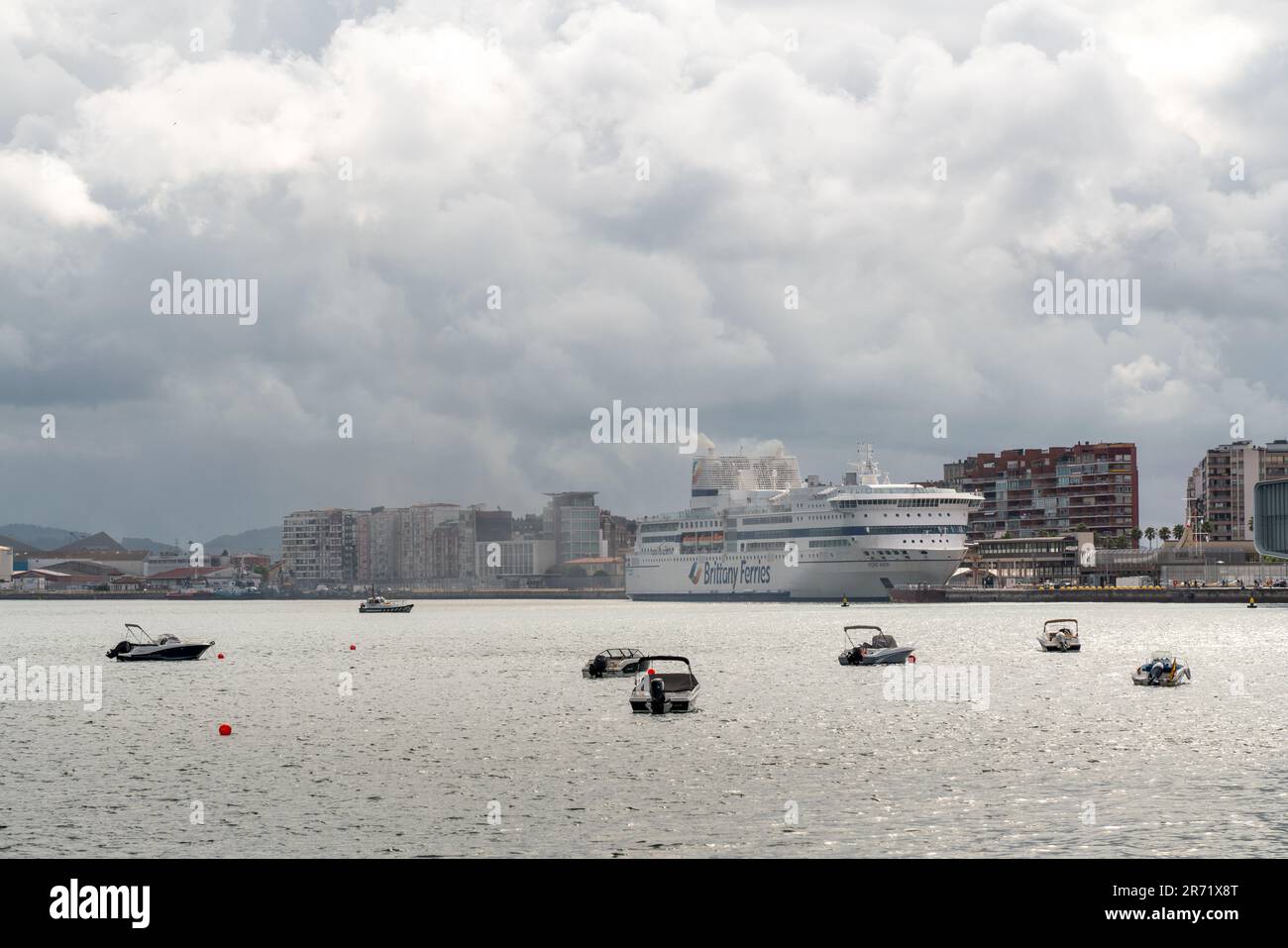 Wunderschöne Santander Bay an einem bewölkten Tag. Boote, die in der Mitte der Bucht anlegen. Blick auf das im Santander Terminal angedockte Schiff der BRETAGNE-FÄHREN Stockfoto