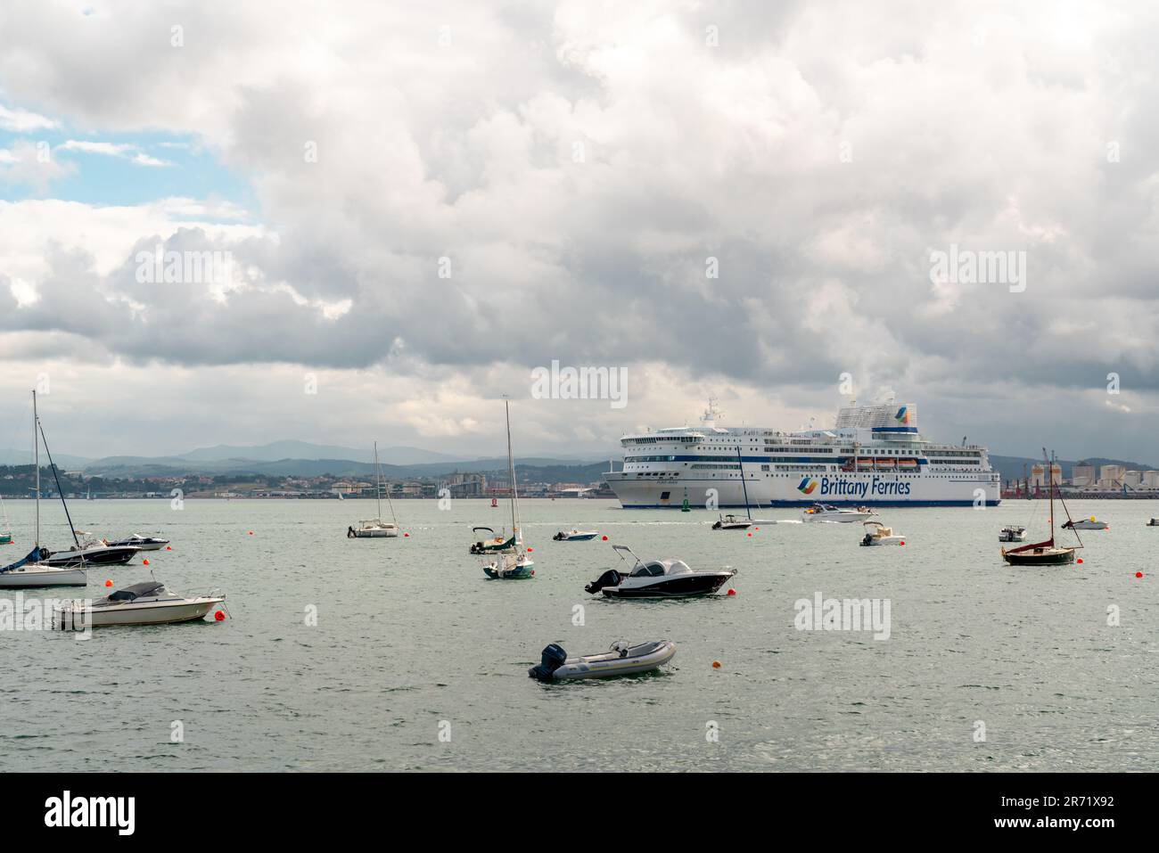 Wunderschöne Santander Bay an einem bewölkten Tag. Boote, die in der Mitte der Bucht anlegen. Blick auf das im Santander Terminal angedockte Schiff der BRETAGNE-FÄHREN Stockfoto
