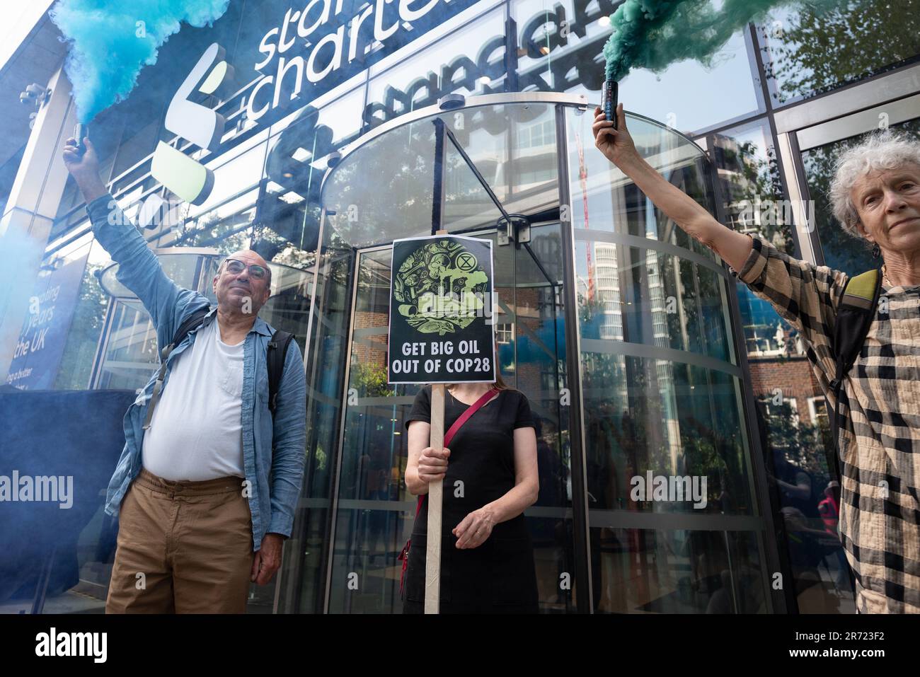 London, Großbritannien. 12. Juni 2023. Klimaaktivisten zündeten vor den Büros der Standard Chartered Bank an einem Vormittag der Proteste in der Londoner City gegen Geldgeber fossiler Brennstoffe und den Einfluss von „Big Oil“ auf die bevorstehenden Klimagespräche COP28 an. Kredit: Ron Fassbender/Alamy Live News Stockfoto
